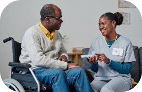 Caretaker caring an elderly man in a wheelchair