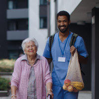 Caretaker helping an elderly woman