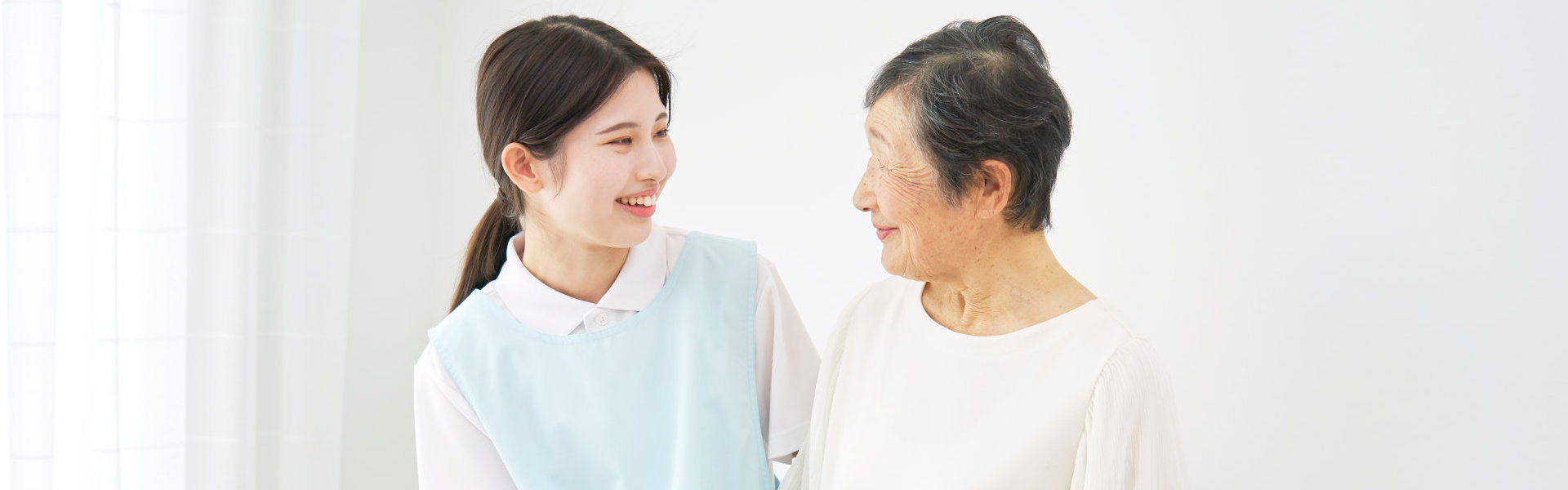 young woman and elderly smiling to each other